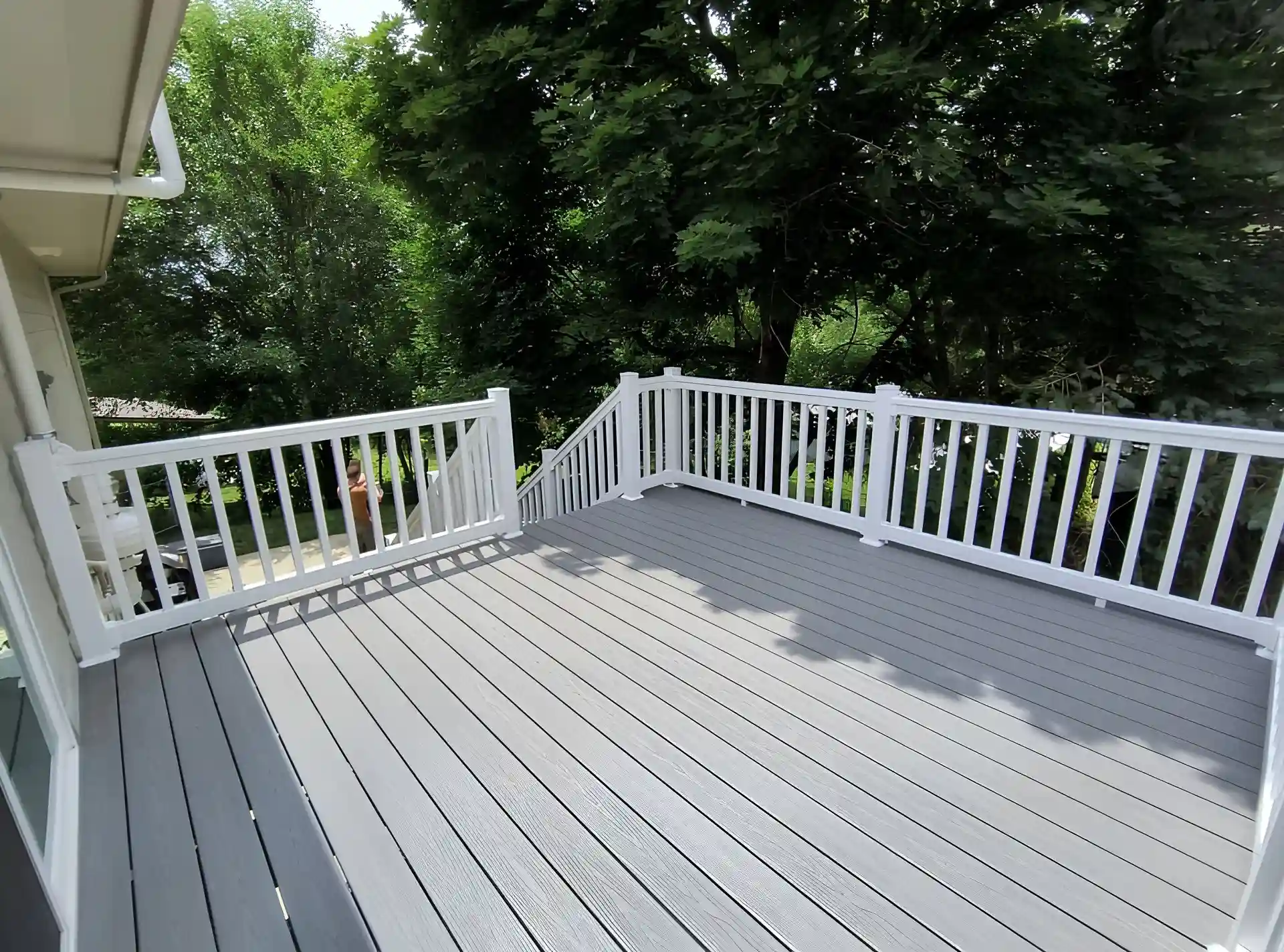 Photo of a a multi-level deck featuring a pool deck and a deck covered with a pergola by Wymore Deck & Fence, trusted West Omaha deck builders.