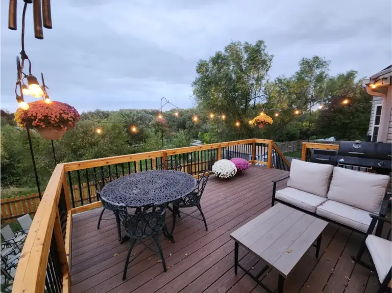 cantilevered deck with outdoor living kitchen and furniture with lighting and nature scenery in omaha ne 768x575