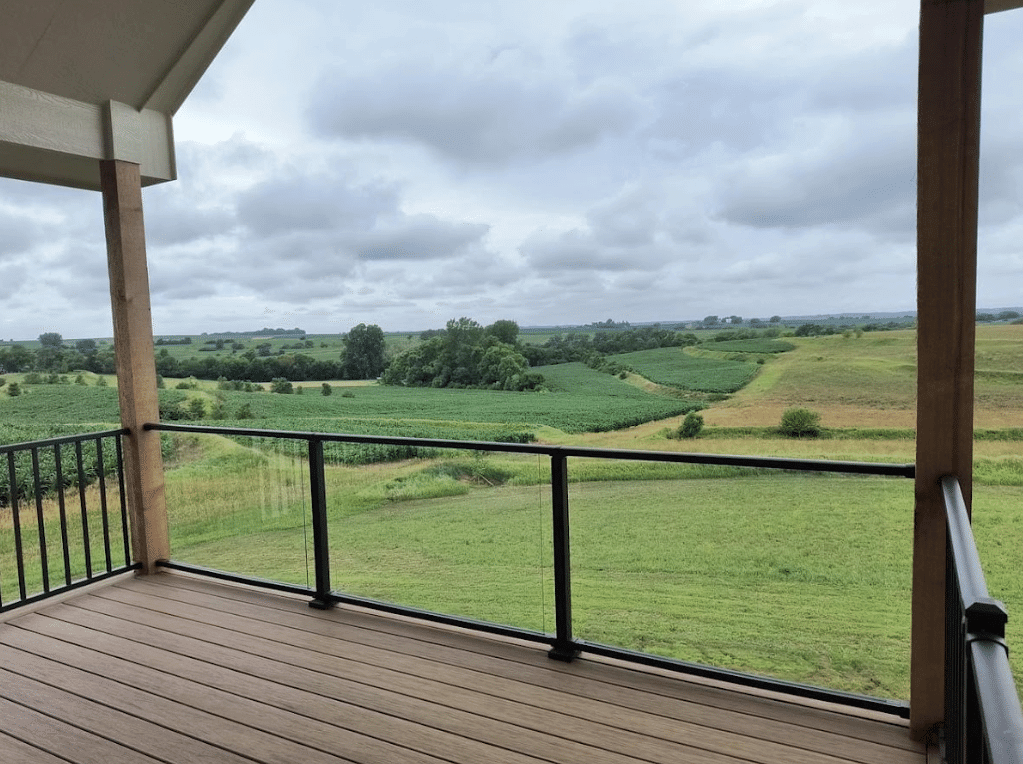 elevated-deck-with-a-glass-deck-railing-and-black-metal-railing-with-overlooking-view-in-omaha-ne