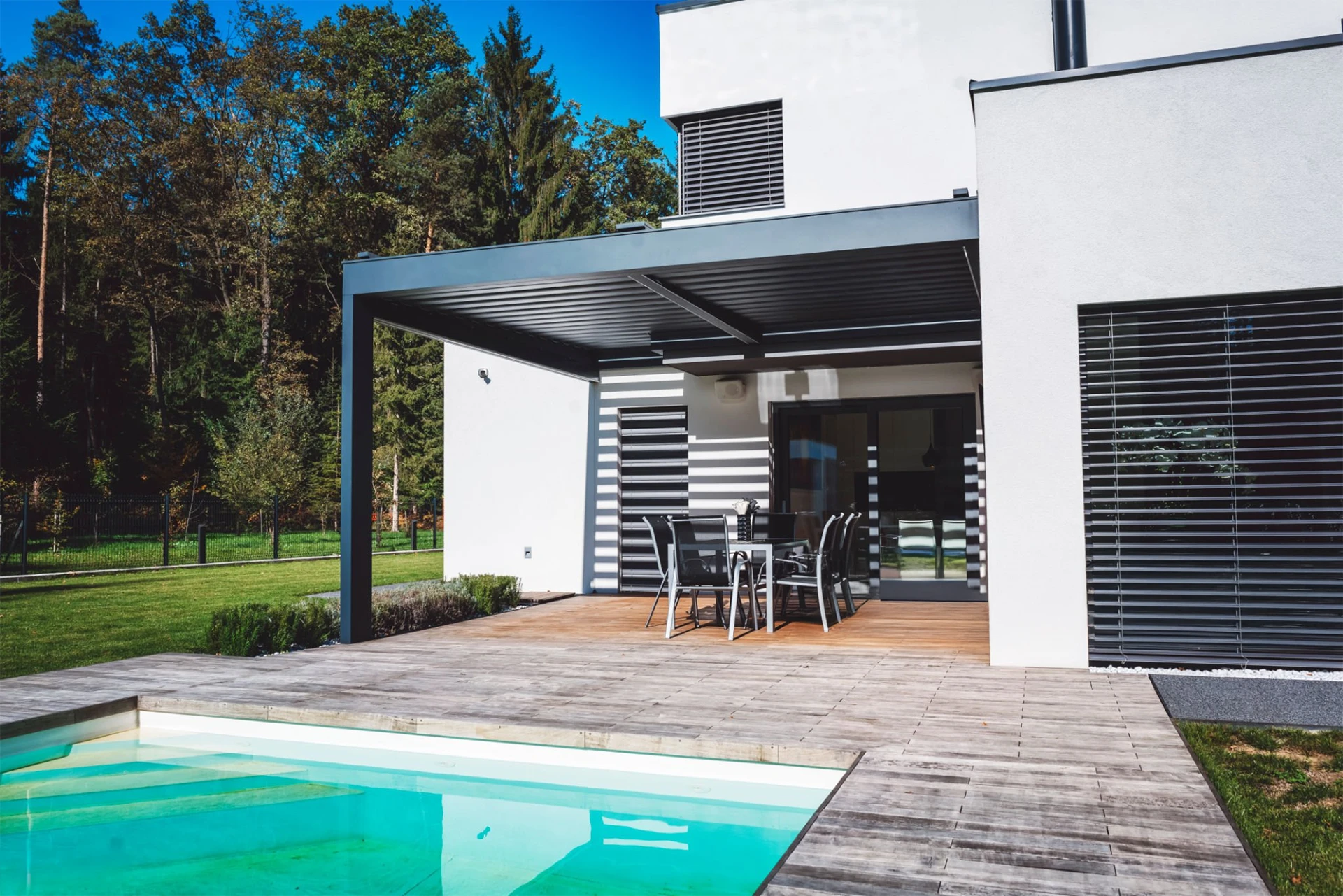 modern-house-with-patio-and-swimming-pool-with-sunroof-pergola-with-big-trees-on-the-background-in-omaha-ne