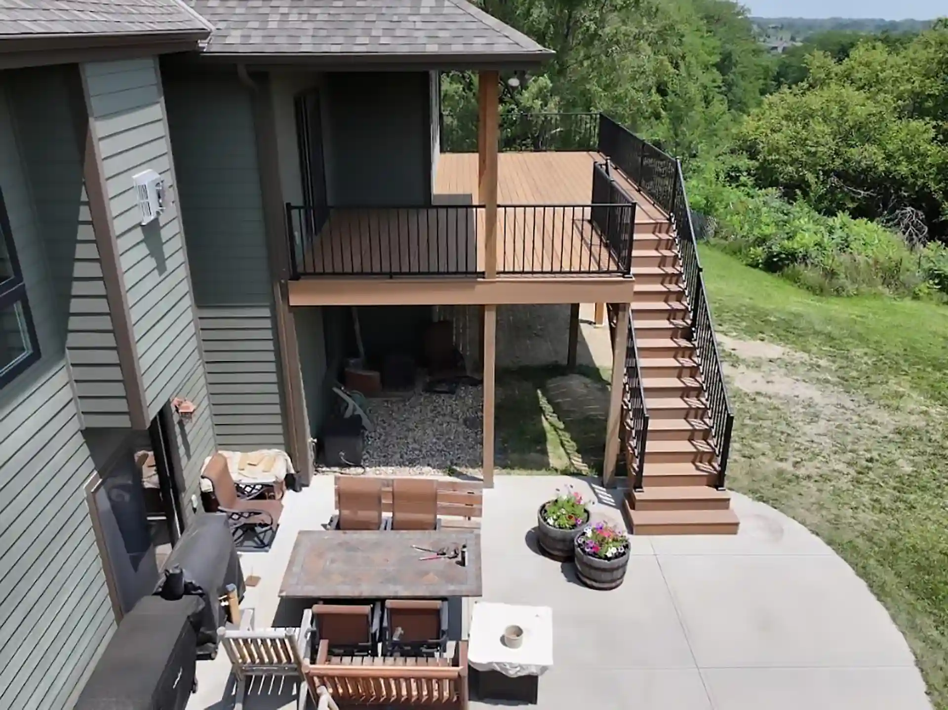 open-patio-with-outdoor-living-space-and-elevated-residential-deck-with-black-railing-in-omaha-ne