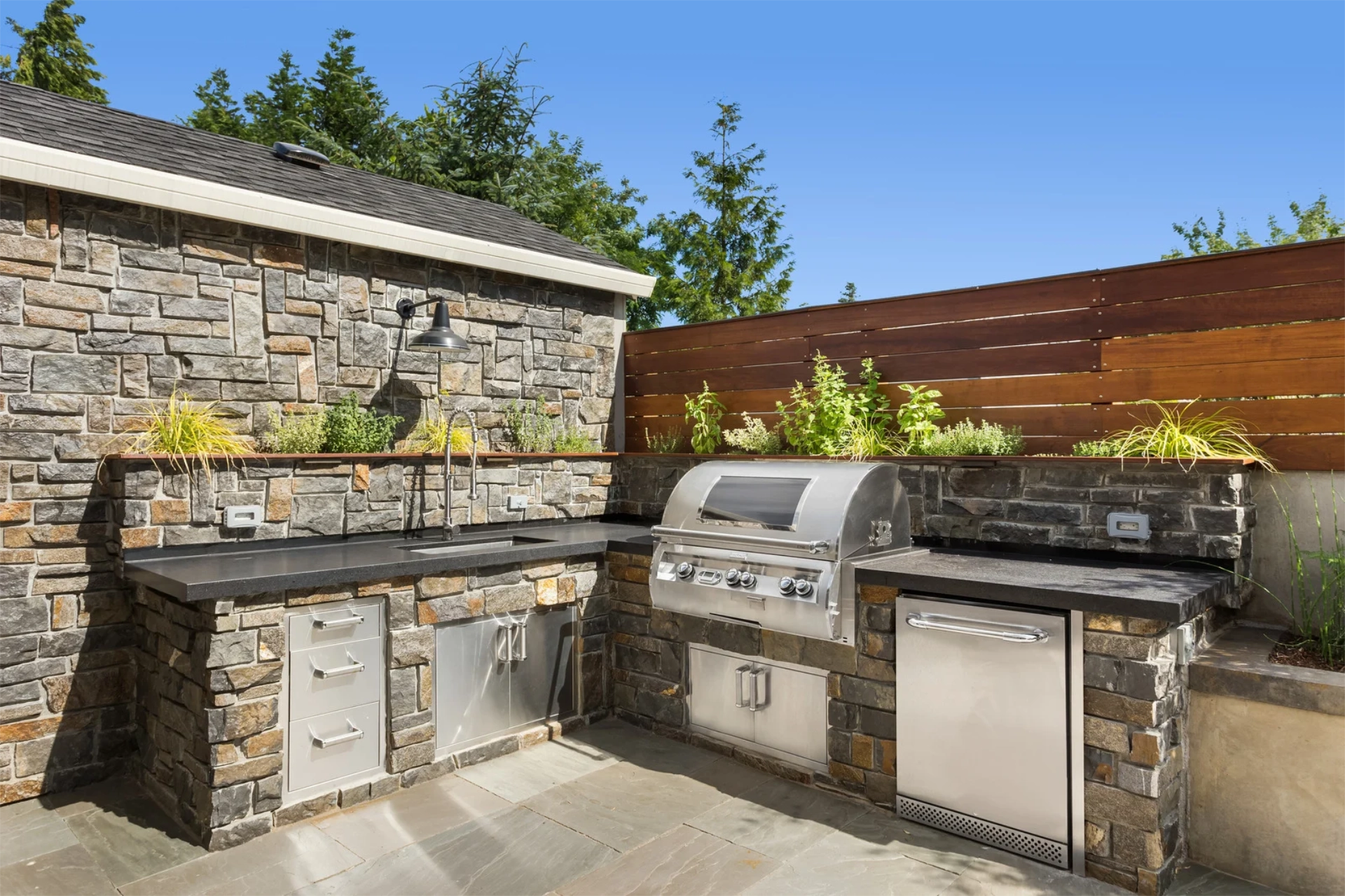 outdoor-living-kitchen-in-paver-with-wooden-privacy-fence-in-omaha-ne