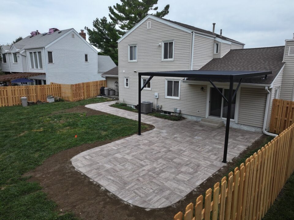 patio-with-black-metal-pergola-and-wooden-fence-in-omaha-ne