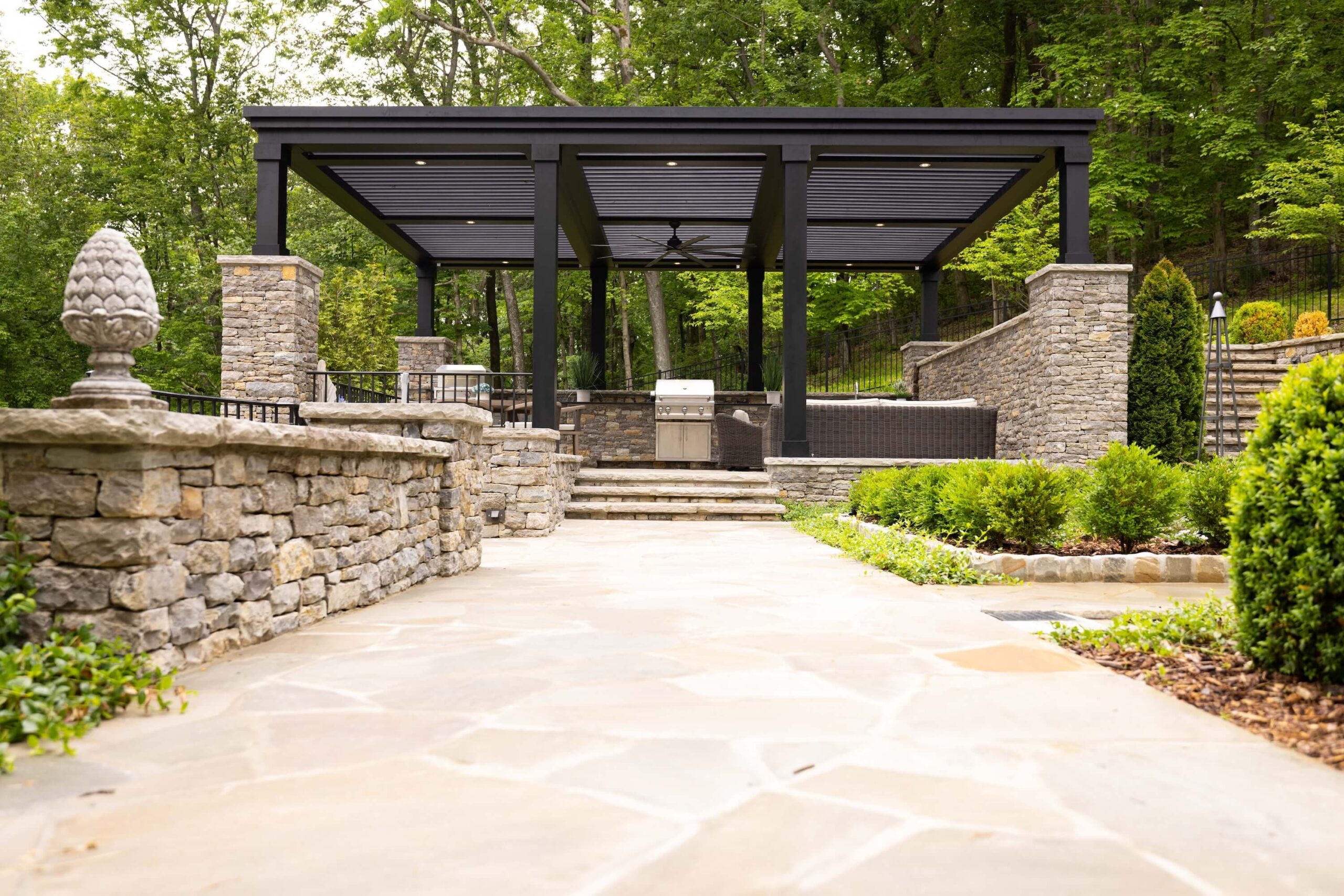 pergola-with-outdoor-kitchen-and-couches-with-black-railing-in-omaha-ne