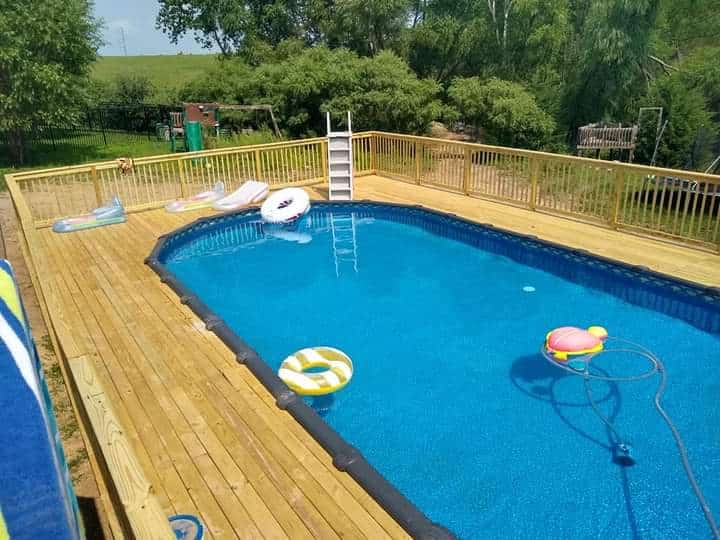 wooden-deck-with-wooden-railing-on-the-pool-with-entertainment-things-in-omaha-ne